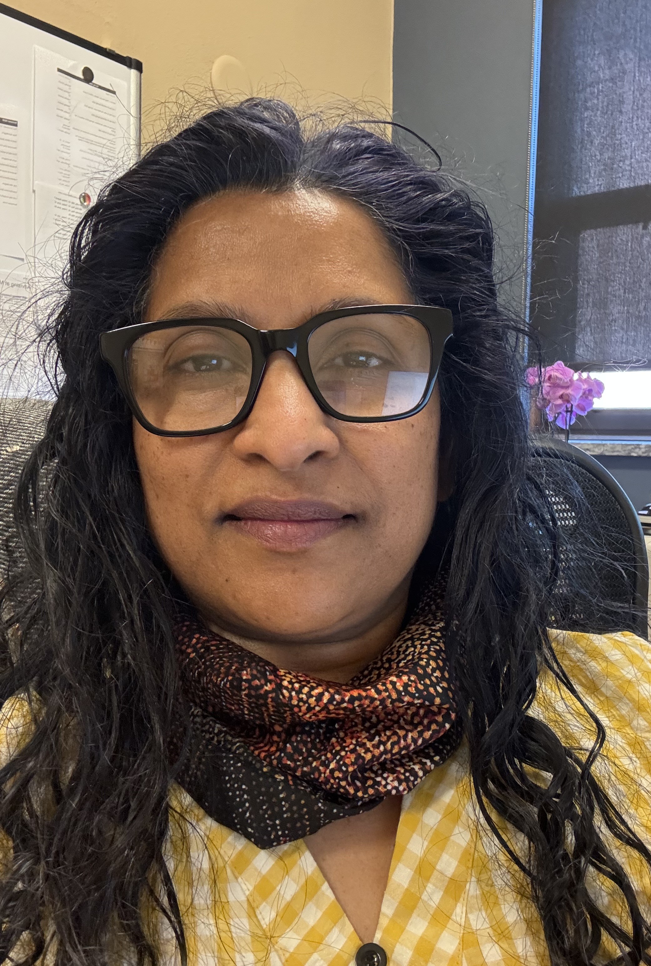 woman wearing glasses, scarf and yellow checkered shirt