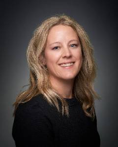 A woman in a side profile smiling